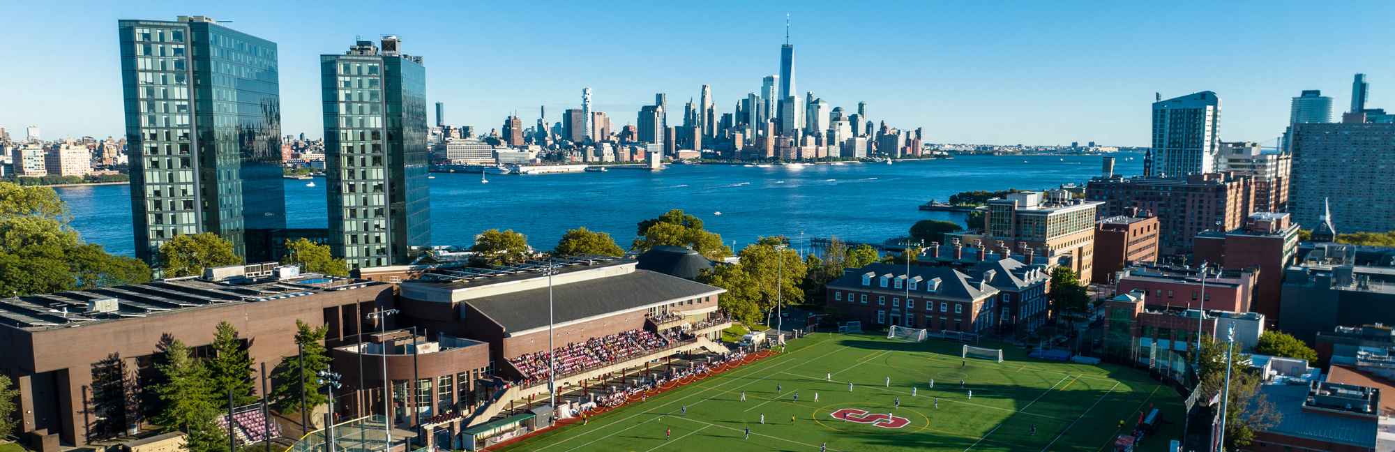 Wide panorama of the Stevens campus along the Hudson River shoreline
