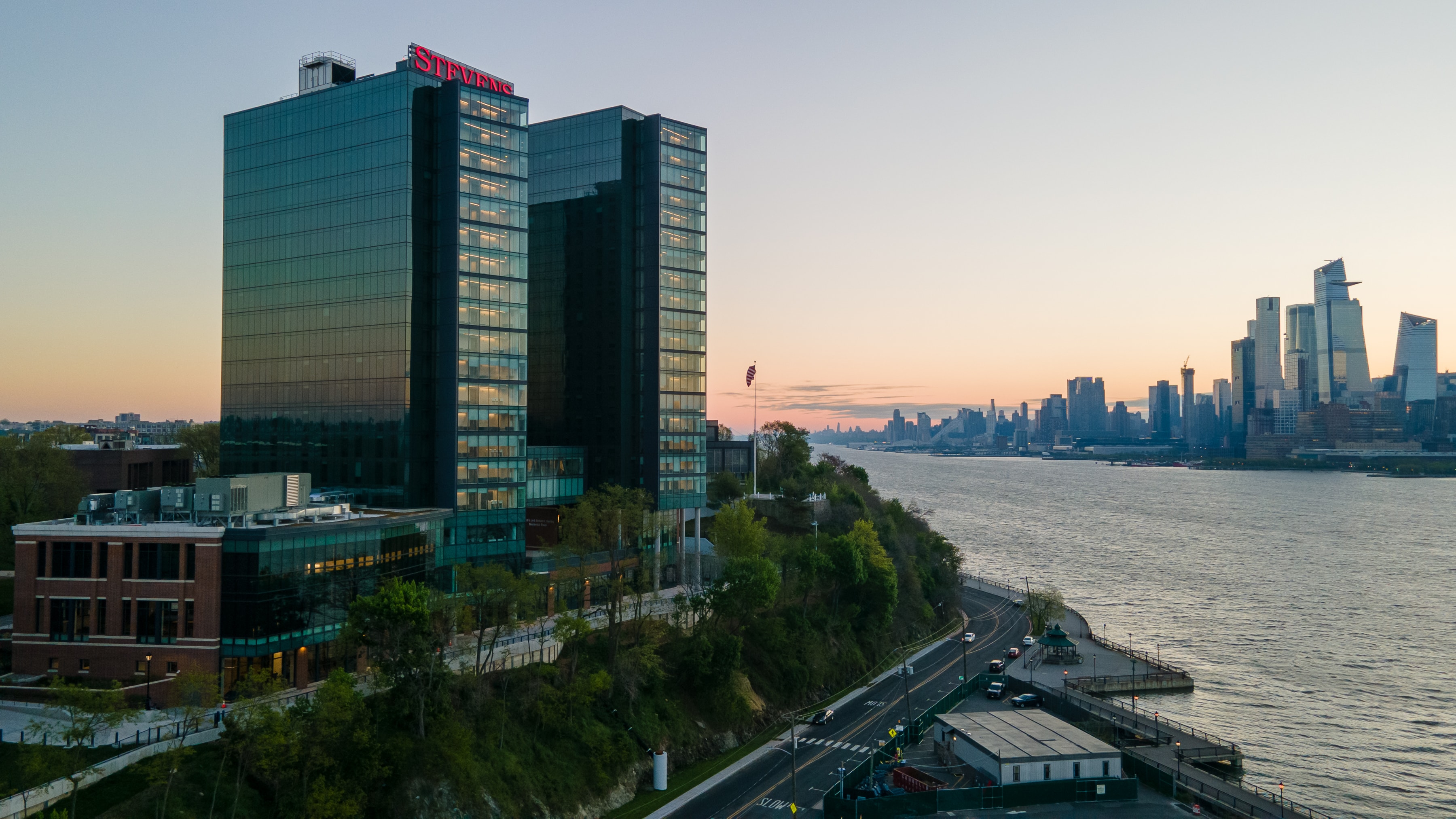 The campus towers at dusk seen from the Hudson River waterfront